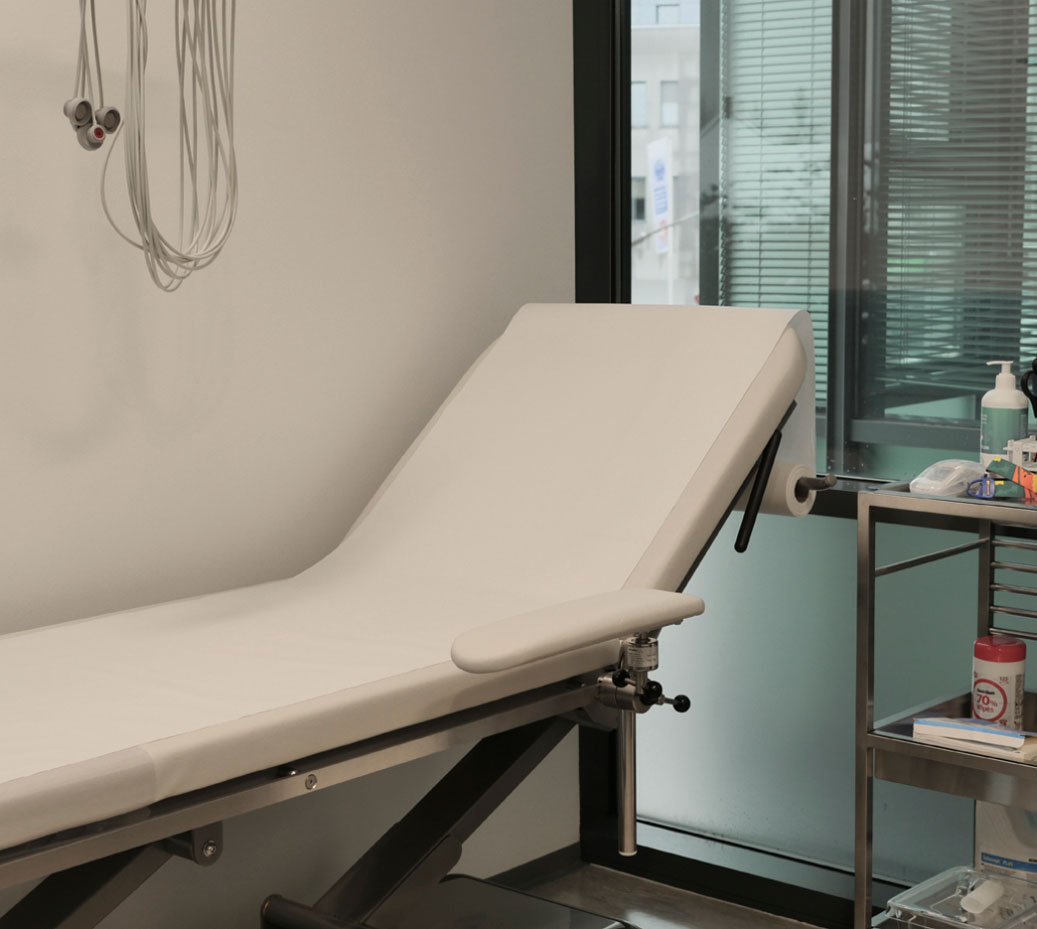 examination table with armrests on fixation rail at medical practice