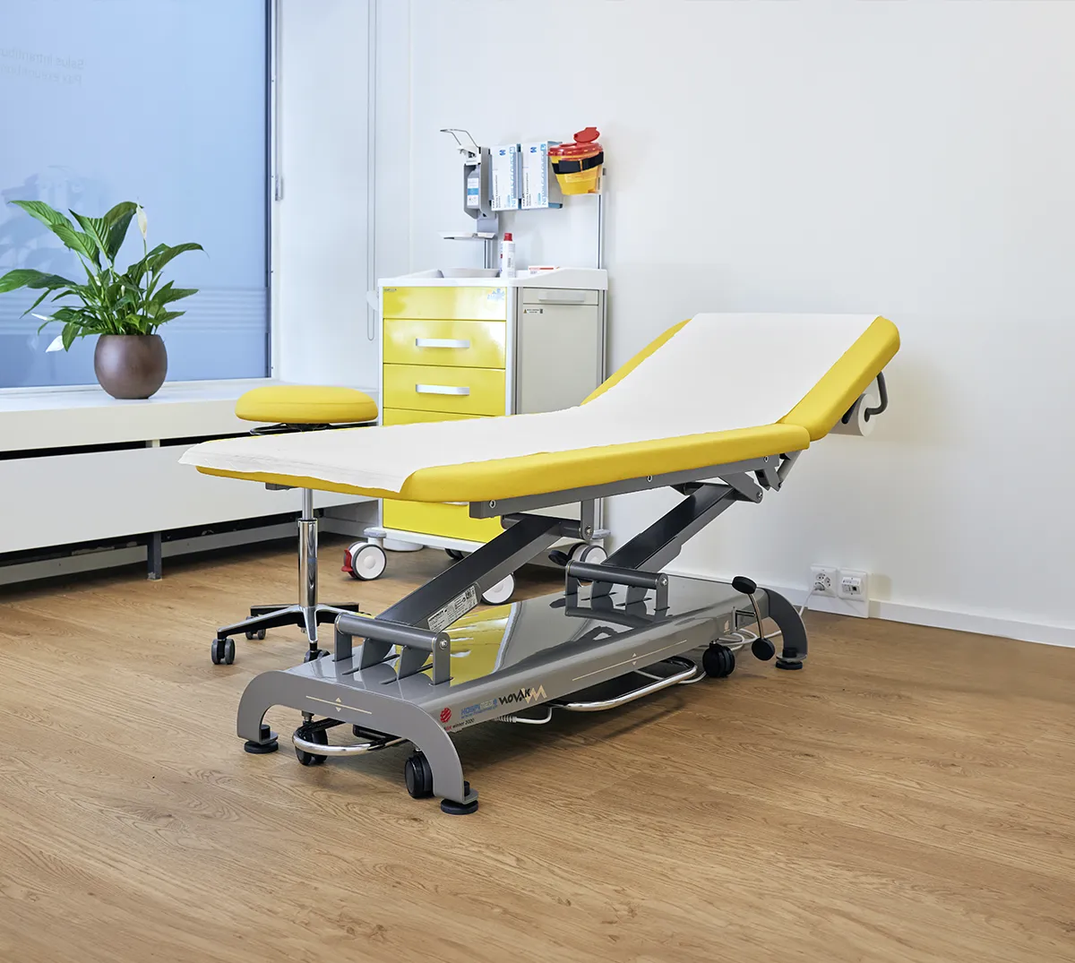 yellow examination table beside stool in an exam room